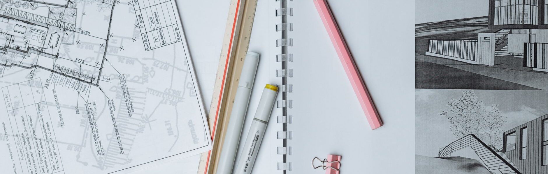 architectural sketches and drafting tools on a desk