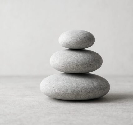 Three stacked smooth stones on a neutral background