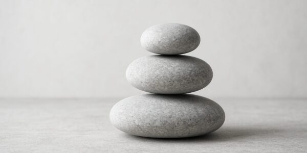 Three stacked smooth stones on a neutral background
